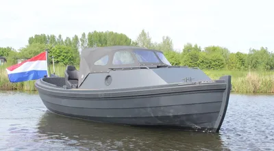 grijze motorboot op water met vlag