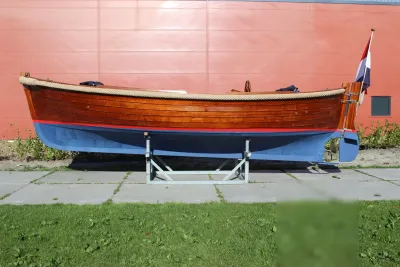 houten sloep op standaard voor rode wand