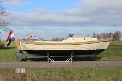 sloep op bok langs grasland