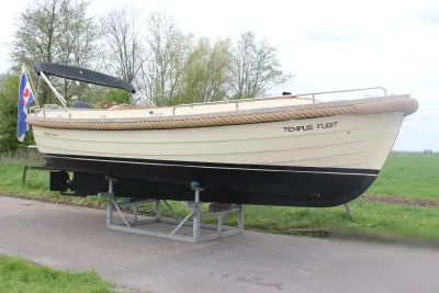 Motorboot op bok naast weg en gras