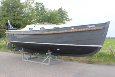 grijze sloep op bok naast grasland