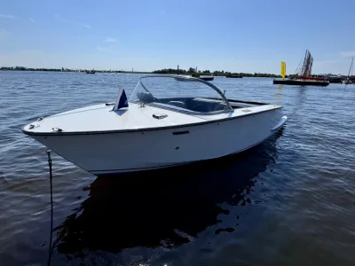 witte open motorboot op rustig water