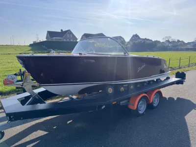 klassieke houten boot op trailer langs weg