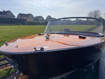 boeg van houten boot op trailer in veld