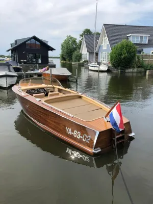 houten sloep in kanaal bij huizen