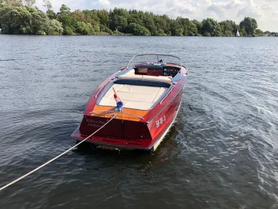 houten motorboot op water bij beboste oever