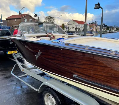 houten motorboot aan trailer bij water