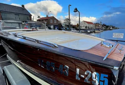 houten motorboot op trailer bij kanaal