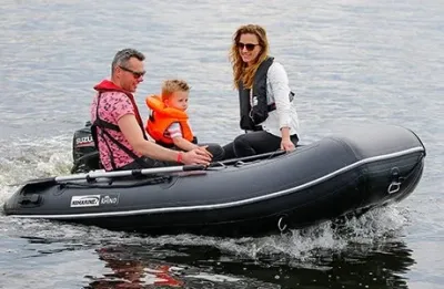 zwarte rubberboot met drie personen