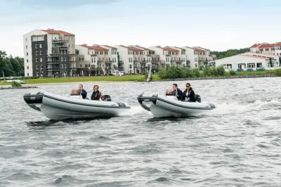 Twee RIB-boten op open water bij bebouwing