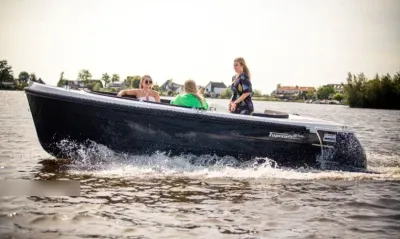 sloep met drie mensen op open water