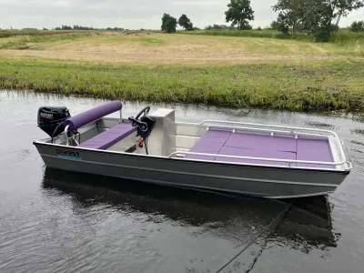 aluminium boot met paarse kussens in water