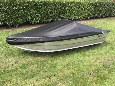 kleine aluminium boot met hoes op gras