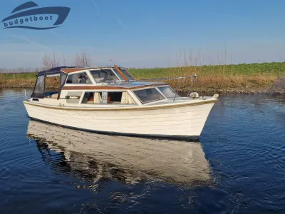 wit motorjacht op rustige waterweg