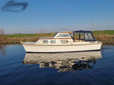 wit houten motorjacht op rustig water
