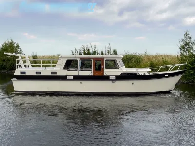 motorjacht op rustig water langs grasoevers