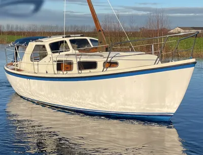zeiljacht op stil water bij oever
