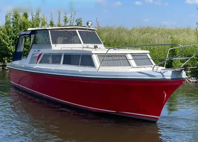 rood motorjacht afgemeerd bij rietkade