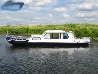 Witte kajuitboot op kanaal bij oever