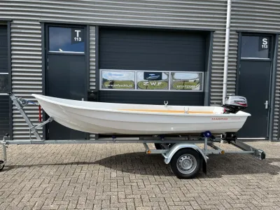 kleine witte boot op trailer voor bedrijfsdeur