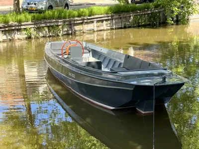 Stalen sloep in kanaal bij kade