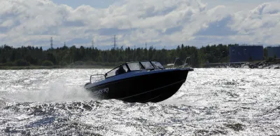 motorboot op glinsterend water met bos op achtergrond