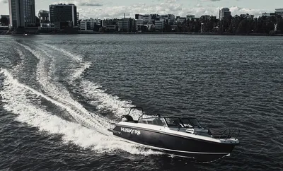 motorboot met wake bij stad op de achtergrond