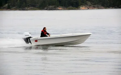 witte motorboot met bestuurder op open water