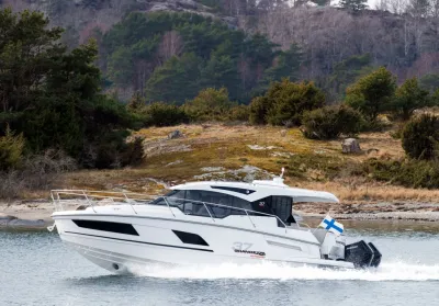 wit motorjacht bij rotsachtige kust