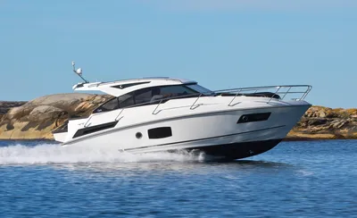 motorjacht varend langs rotsachtige kust