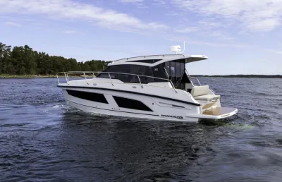 motorjacht op zee bij beboste kust