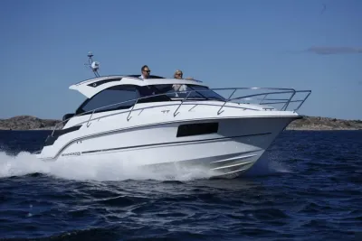 witte motorboot varend bij rotsachtige kust