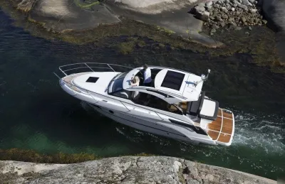 wit motorjacht vaart door rotsachtige doorgang