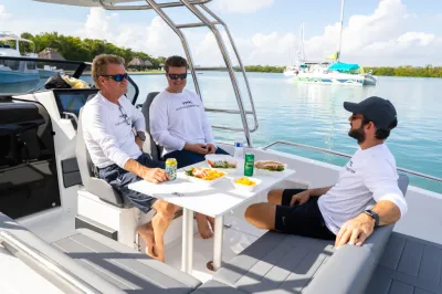 drie personen zittend aan tafel op boot