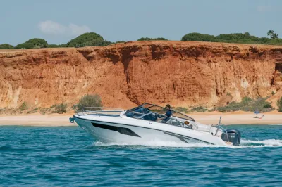 motorboot op zee bij roodgekleurde kust