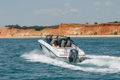 Snelboot op zee met kust op de achtergrond
