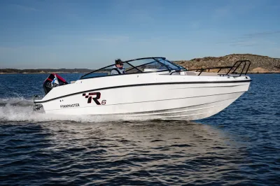 witte boot op zee met rotsachtige kust