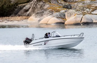 open consoleboot varend langs rotsachtige kust