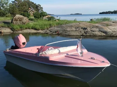 roze open boot bij rotsachtige kust
