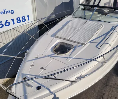 boeg van witte sportcruiser bij loods
