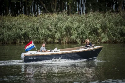 sloep met twee personen op een rivier