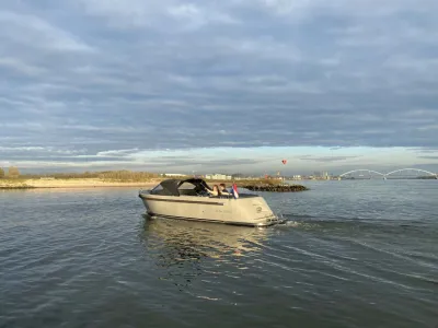 Sloep varend op rustig water bij kust