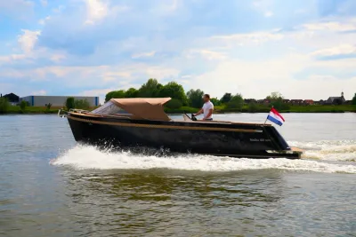 Zwarte sloep op het water met bestuurder