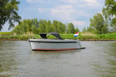 sloep op rustig water bij oever