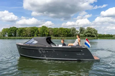 zwarte sloep op het water met twee mensen