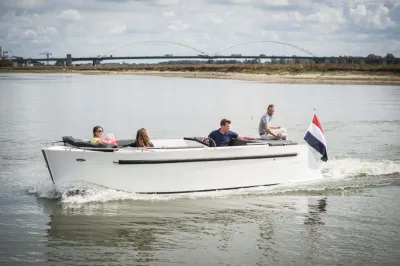 Witte sloep met vier personen op het water