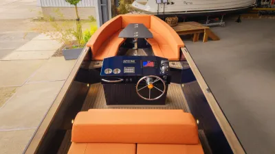tender met oranje kussens en stuurconsole