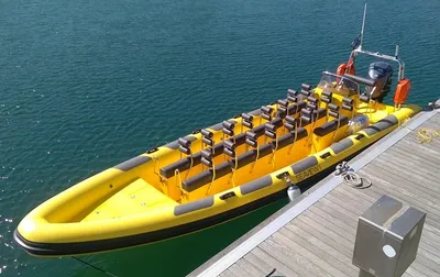 gele ribboot afgemeerd aan een steiger