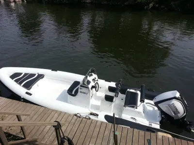 witte ribboot aangemeerd bij houten steiger