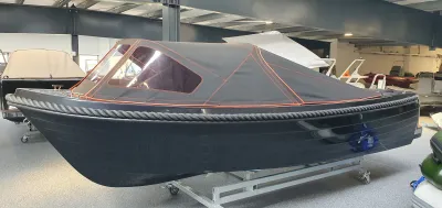 zwarte sloep met huif in binnenshowroom